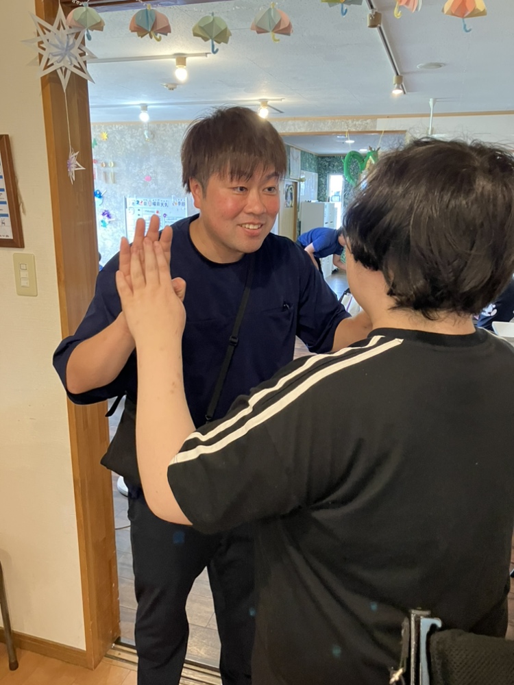 利用者さんとハイタッチを交わす砂壁進策さん