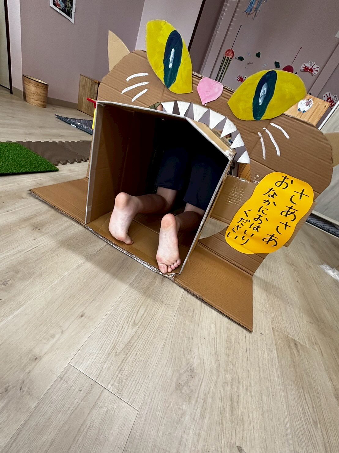 段ボールのやまねこに入って遊ぶ様子