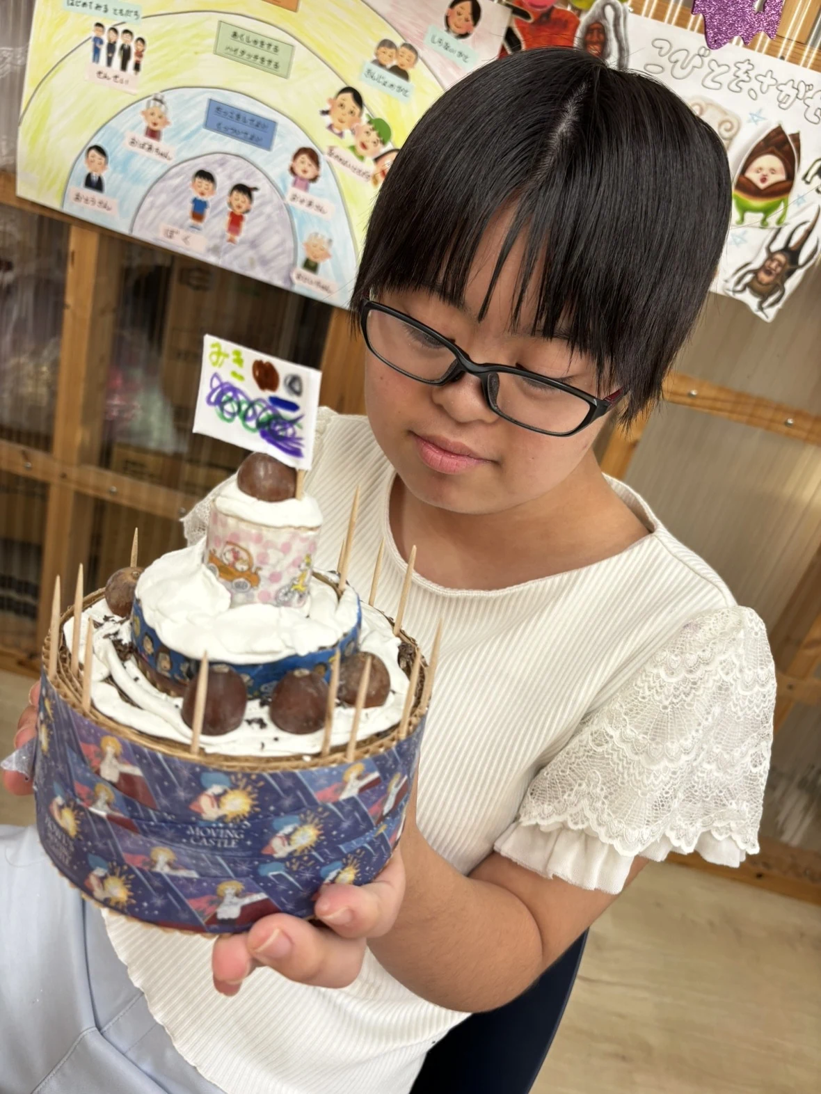 木の実でつくったケーキを手にする子ども