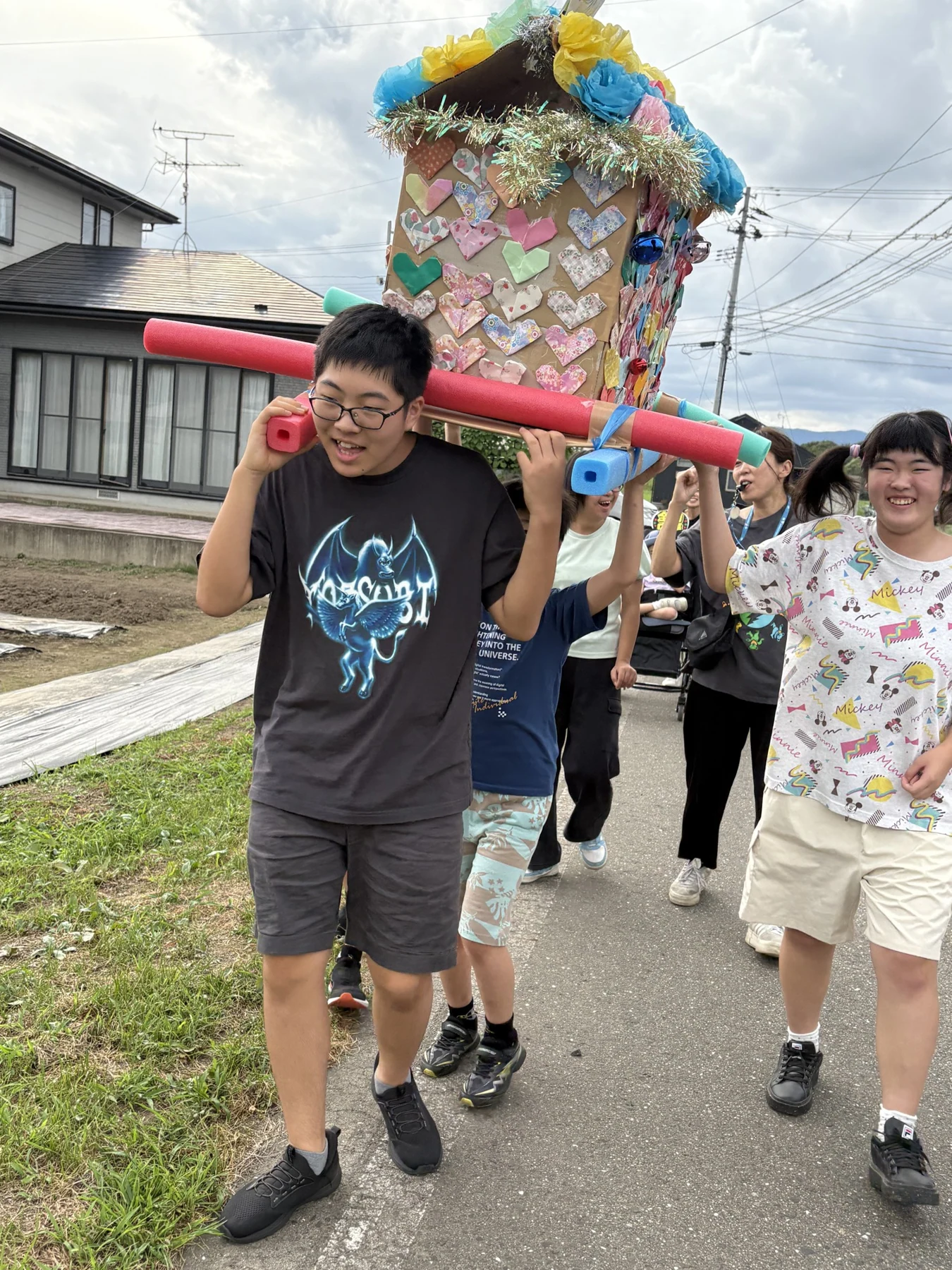 手づくりのおみこしを担いで歩く子どもたち